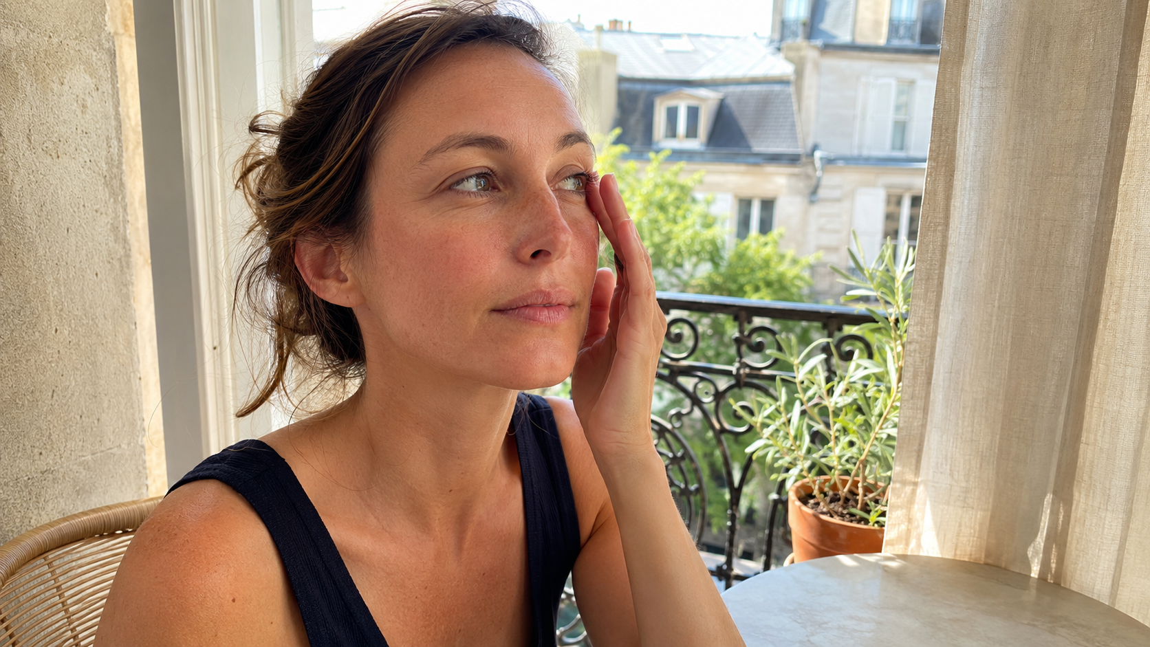 Femme protégeant son visage du soleil en été avec une peau sensible et lumineuse