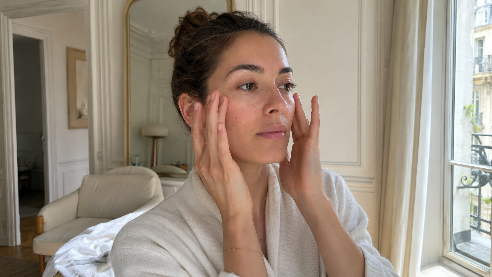 Femme pratiquant un automassage doux du visage dans une routine de yoga du visage à Paris 15